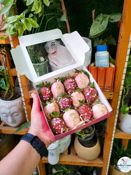 A box of Valentine's themed chocolate-dipped strawberries. The pink and red sprinkles make them perfect for a romantic gift.