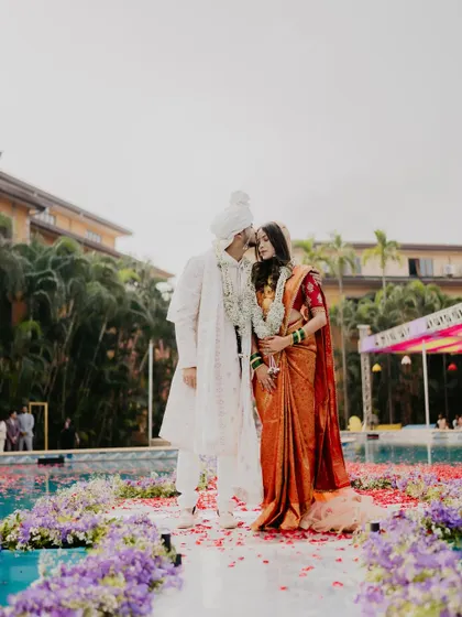 A romantic poolside portrait of the couple. The bride's elegant saree and the groom's coordinated white sherwani create a picture of modern love.