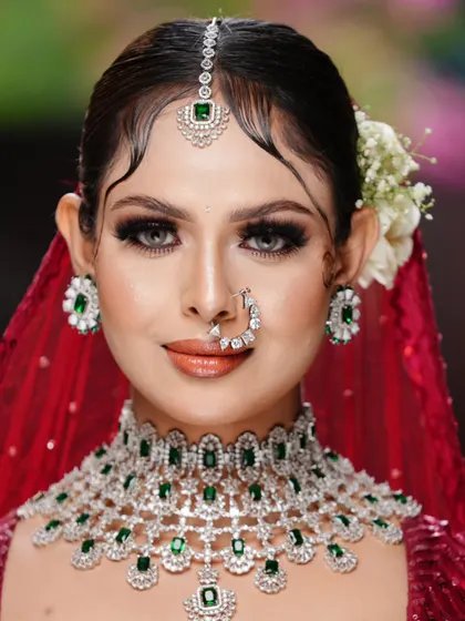 A direct, powerful gaze from the bride. This shot showcases the symmetry and precision of the makeup application, from the perfectly shaped brows to the expertly blended eyeshadow and contour.