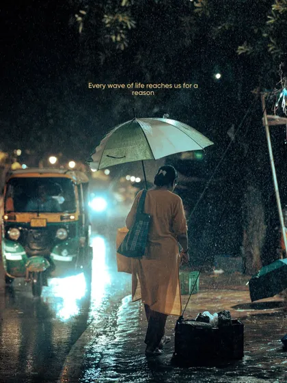 A woman walks along the roadside in the rain, with the headlights of an auto-rickshaw creating a beautiful backlight. These are the fleeting, story-filled moments I'm always searching for.