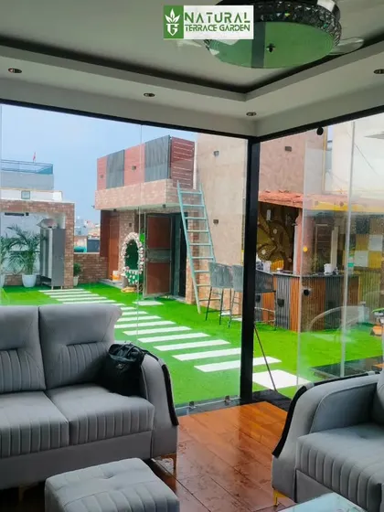 A view from inside the glass house, looking out onto the beautifully landscaped terrace in Shahdara.