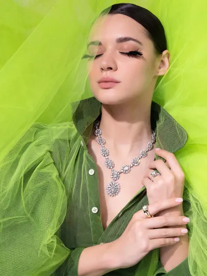 A solo shot from the IGI campaign, with the model enveloped in lime green tulle, creating a fresh, summery vibe for the diamond necklace.