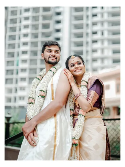 A serene portrait of a newly married couple, framed by the modern architecture of their surroundings.
