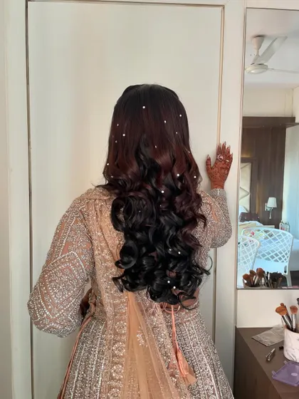 For her reception, we styled her hair in soft, open curls, scattering delicate pearls throughout for a touch of starry elegance.