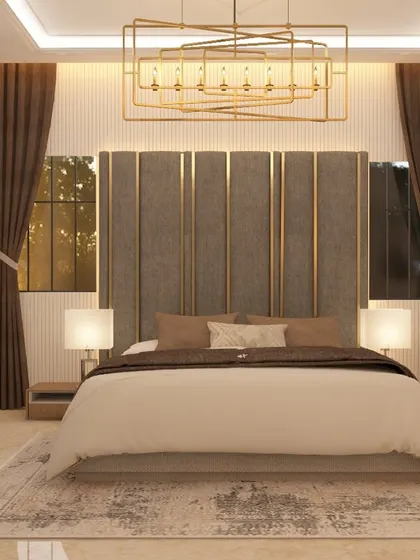 This master bedroom exudes elegance with a tall, upholstered headboard featuring vertical panels and gold trim. The matching bedside lamps and rich brown curtains complete the luxurious and cohesive look.