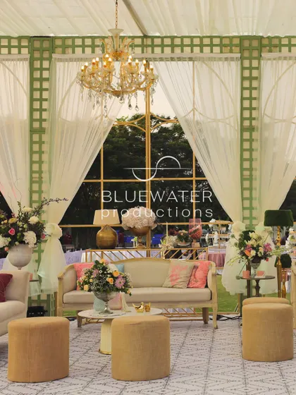 The interior of the family lounge, featuring elegant furniture, chandeliers, and large windows looking out onto the wedding.