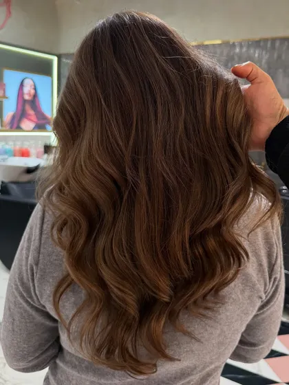My hand holding up a section of this deep ash blonde hair, showing the beautiful, cool-toned dimension and healthy shine.