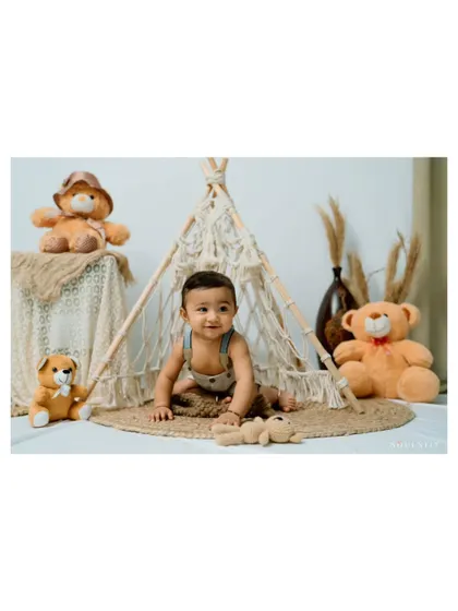 A tiny explorer in his own little world. The boho setup with a teepee creates a magical space for imaginative play.