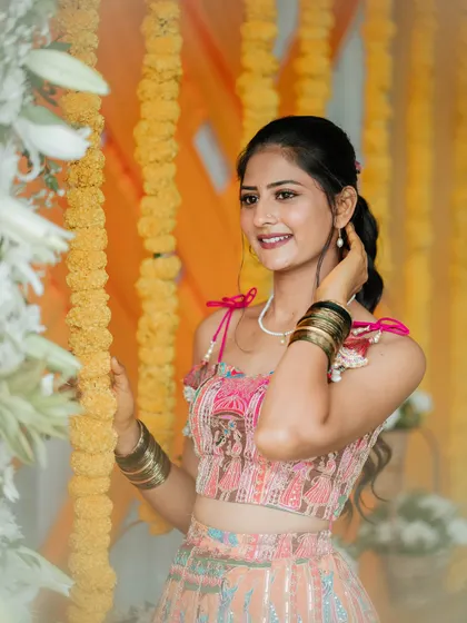 For Chethana's mehendi ceremony, I created this vibrant and playful lehenga. The skirt features colorful patchwork embroidery, and the blouse is designed with a modern tie-up back and charming tassels.