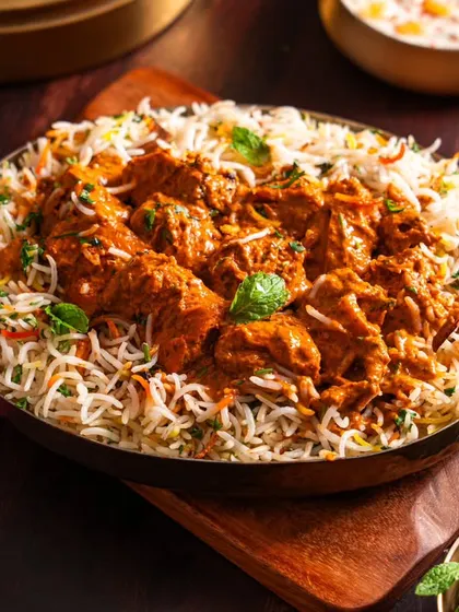 A rich and inviting bowl of biryani from Sadak Chaap. The warm lighting and traditional serving dish create a rustic and authentic feel, perfect for a delivery-focused brand.