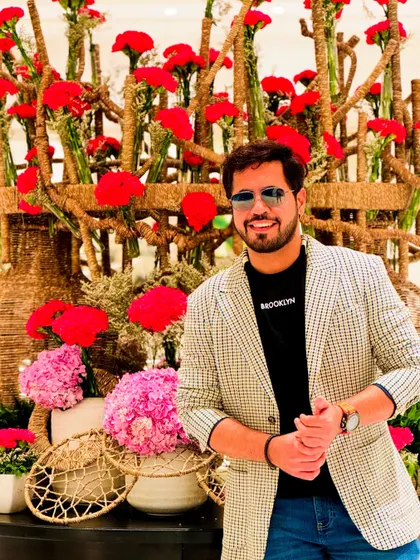 A smart casual look with a checkered blazer, perfect for a daytime event or a stylish appearance in Kolkata. The floral background adds a great pop of color.