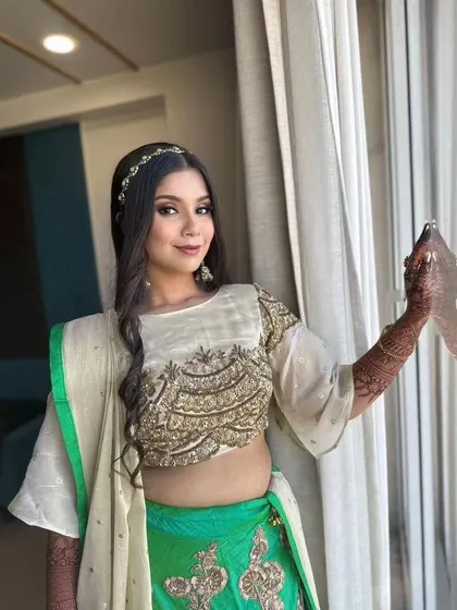 A soft glam look for a Mayra ceremony. The bride's green and cream outfit is paired with natural makeup and loose, wavy hair.