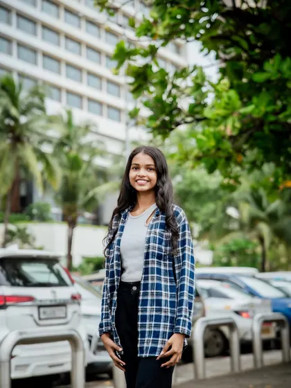 A smiling portrait with a clean, urban background. This is a great example of a simple, effective headshot taken outdoors.