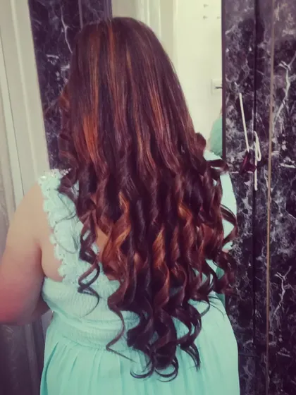 A beautiful example of defined, spiral curls on highlighted hair, creating a look full of texture and dimension.