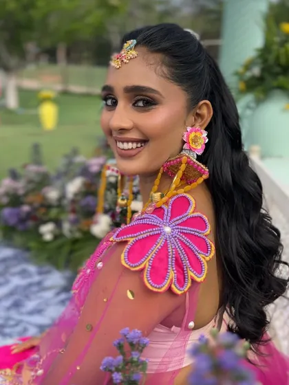 The client smiling, showing off her playful high ponytail and colorful outfit.