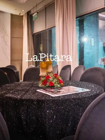 A close-up of the elegant table setting, with black sequined linens and chairs featuring ornate gold details.
