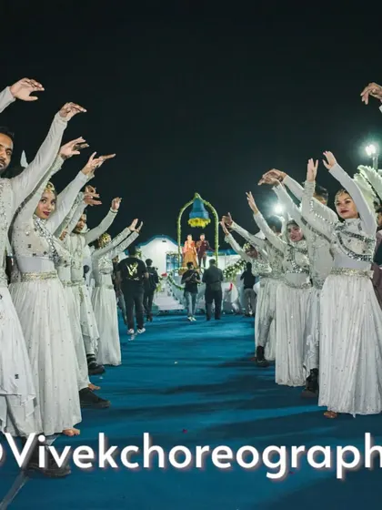 The pathway to a dreamy varmala. Dancers in elegant white costumes create a beautiful formation, welcoming the couple as they proceed towards the main stage.