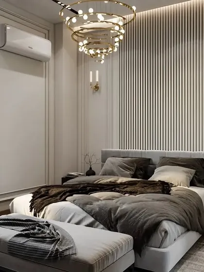 A classic and elegant bedroom with white walls featuring decorative molding, a fluted accent panel, and a stunning modern chandelier. The neutral tones create a peaceful and timeless look.