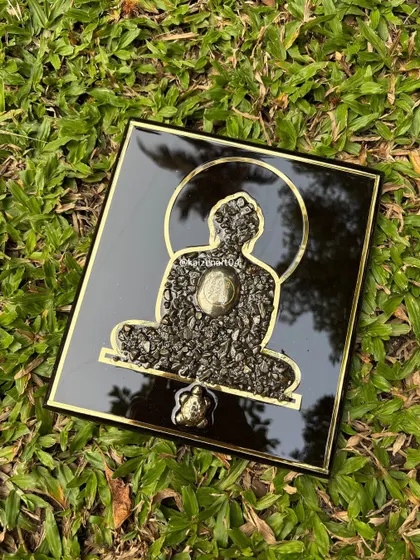 Another angle of the Mahaveer Swami artwork, highlighting the glossy black background and the golden halo. The reflection shows the mirror-like finish of the resin.