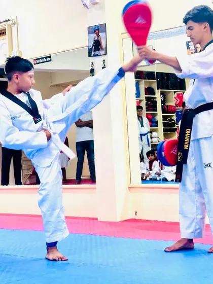 A student executes a powerful kick during a target practice session.
