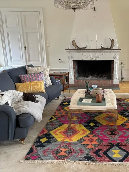 I love seeing how our pieces fit perfectly into a client's living space. This bold, colorful geometric dhurrie brings so much life and personality to this elegant room, proving that a rug can be a true statement piece.