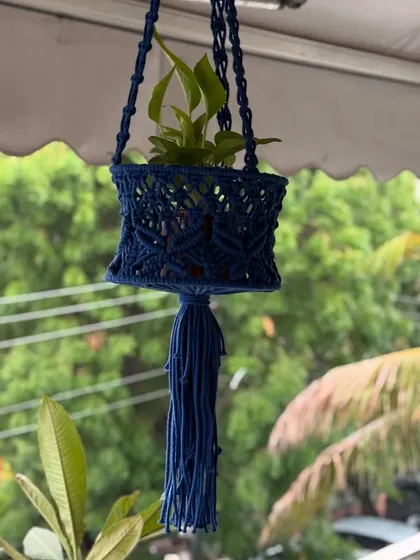 A closer look at the intricate knotting on the navy blue hanging basket. It's strong enough to hold a variety of small to medium-sized plants.