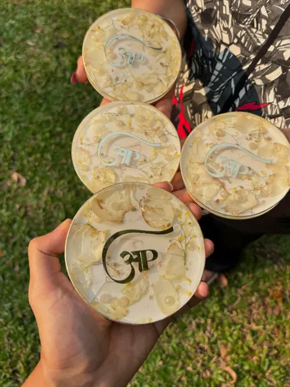 A set of four coasters made by preserving wedding flowers, each personalized with the couple's logo. This is a great idea for wedding favors or as a gift to the couple.