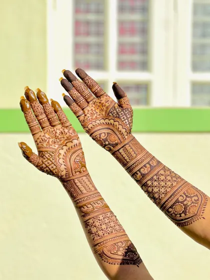 The beautiful stain of an intricate bridal design, captured in bright sunlight. The patterns include elephants, lotuses, and geometric checks.