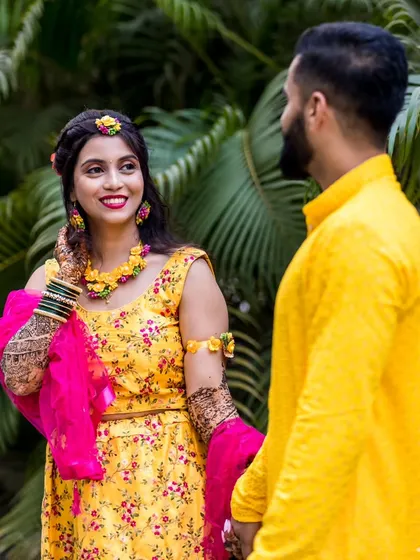 A candid shot from a pre-wedding event. The bride's joyful glance towards her partner captures the excitement and happiness of the occasion.
