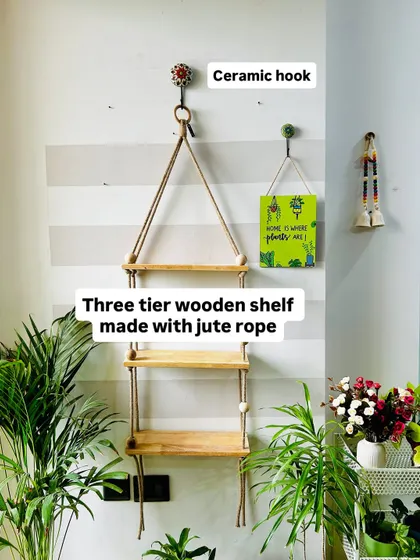 Beauty in simplicity. This three-tier wooden shelf is made with sturdy jute rope and large wooden beads, providing ample space for your favorite plants. It comes with a ceramic wall hook and six ceramic planters to complete the look.