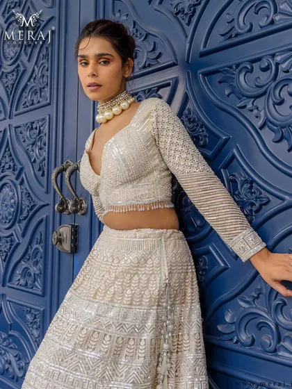 This ivory lehenga with its sharp structure and delicate craftsmanship is perfect for the bride who defines her own royalty.