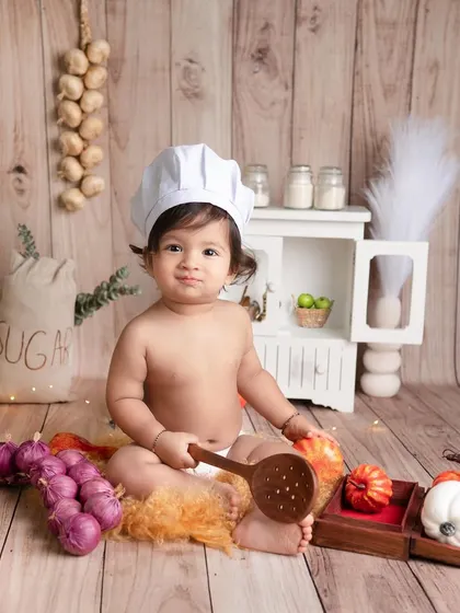 When the chef is this cute, who cares about the food? This little one is cooking up some smiles in our mini-kitchen setup, complete with tiny vegetables and a wooden spoon.