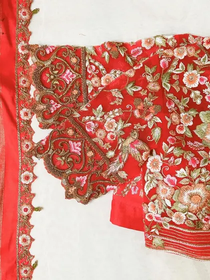 A red blouse beautifully adorned with all-over floral embroidery and lovingly crafted details.