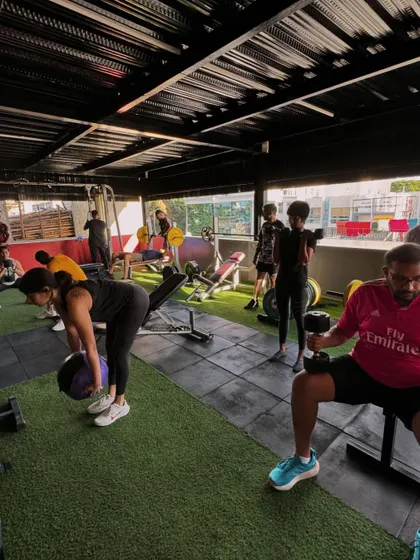 A wide shot of the gym floor, bustling with members working through different exercises. This captures the energy and community spirit of a typical session.