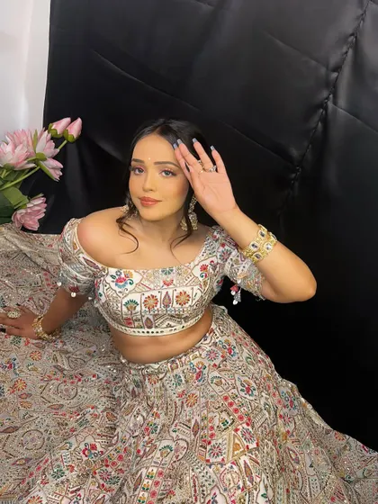 A full-length view of this gorgeous Mehndi look. The off-shoulder blouse and intricate lehenga are perfectly complemented by the soft, romantic makeup.