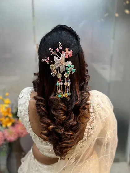 A statement floral and beaded hair accessory takes center stage in this look. Our classes cover how to balance large, ornate pieces with a simple yet elegant hairstyle.