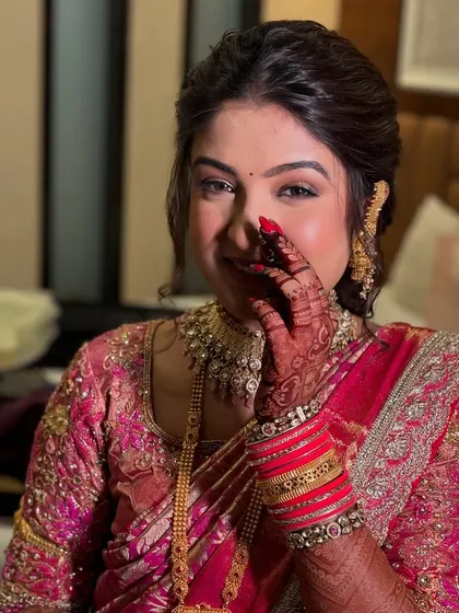 A playful and shy moment captured perfectly. The makeup is designed to look flawless from every angle, with a focus on radiant skin and beautifully defined eyes.