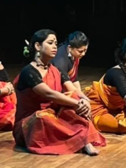 The dancers in 'Songs of the Millstone' listen intently, embodying the characters of women whose stories are often unheard. The production uses simple, earthy costumes to keep the focus on the narrative and emotion.