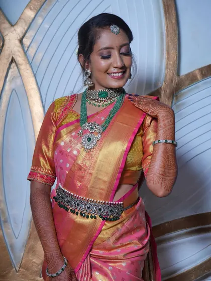 This client looks beautiful in a pink and gold saree, adorned with an elegant emerald and polki set. A perfect look for a festive celebration or a family wedding.