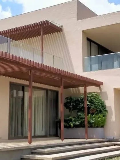 This view of our "House in the Hills" project highlights the use of wooden pergolas and screens. These elements provide shade and privacy while adding a layer of textural warmth to the facade.
