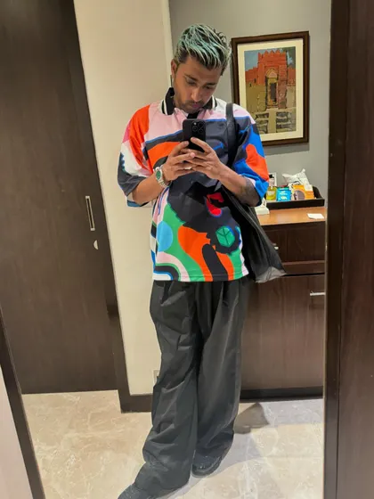 A mirror selfie showing off a colorful fit. My style is a mix of streetwear and comfort, ready for travel and performance.