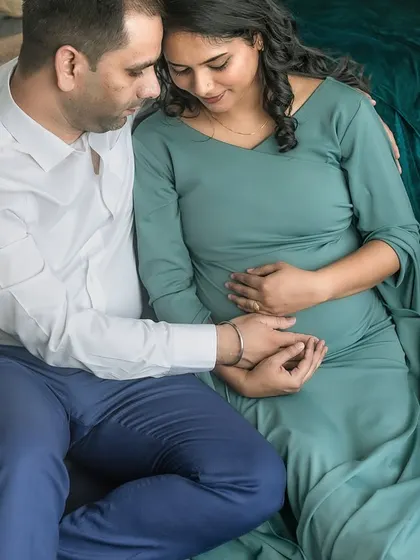 A close, tender moment between the couple, their hands joined over the baby bump. This image is all about the quiet connection and the shared love for their unborn child.