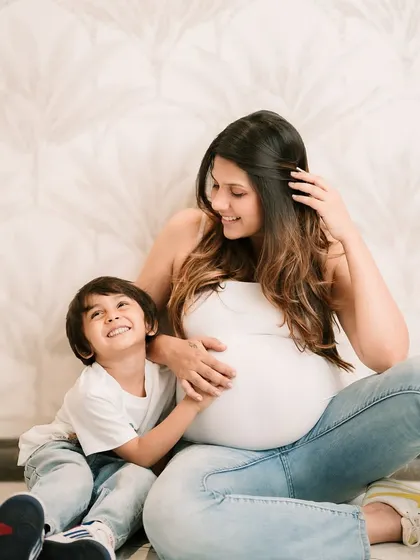 An expectant mother and her son share a happy moment, both looking forward to the new arrival.