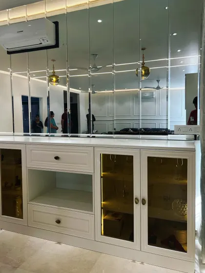 A closer look at the crockery unit, showing the combination of closed drawers, open shelves, and glass-front cabinets with internal lighting.