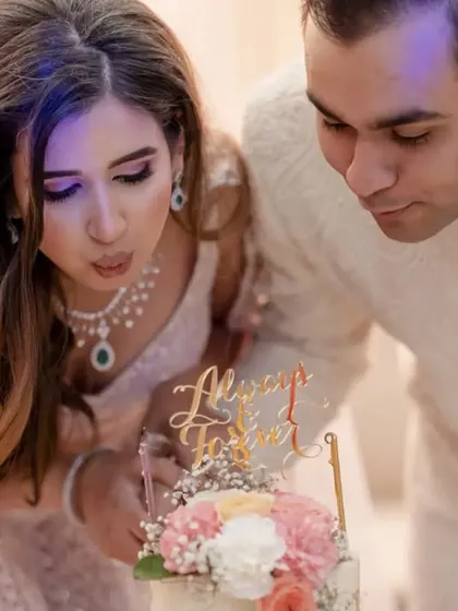 A close up of the couple blowing out the candles on their engagement cake, a moment of shared celebration.