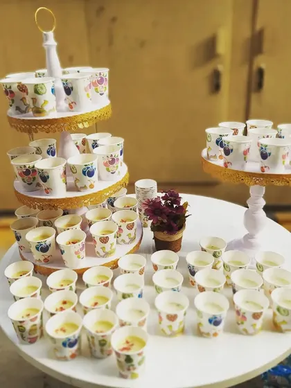 Chilled thandai served in festive paper cups for a corporate Holi celebration. This refreshing traditional drink is a must-have for any Holi party, and we present it beautifully on our tiered stands.