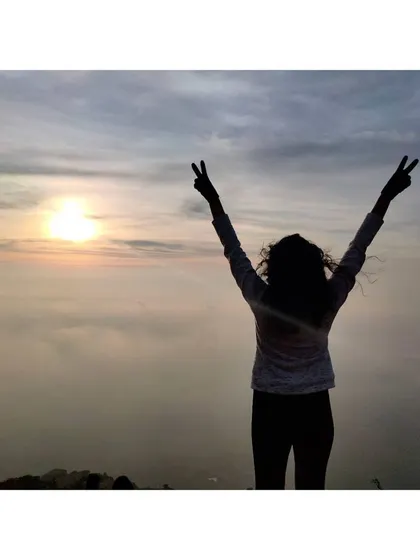 A silhouette of me making peace signs against the sunrise. It's a celebration of a new day and the feeling of freedom.