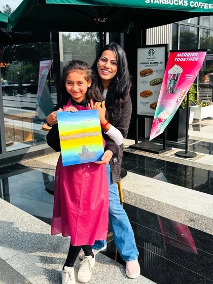 A mother and daughter posing with their finished painting outside the workshop venue. A lovely memory of a day well spent.