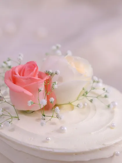 We believe that simple gestures are the most profound. This happy anniversary cake features a clean, white-frosted design, elegantly adorned with fresh pink and white roses, baby's breath, and delicate pearls for a look of pure and simple romance.