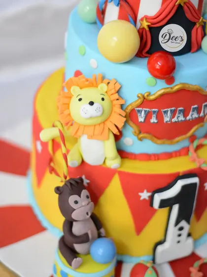 The friendly lion and monkey add to the fun and colorful carnival atmosphere of the cake.